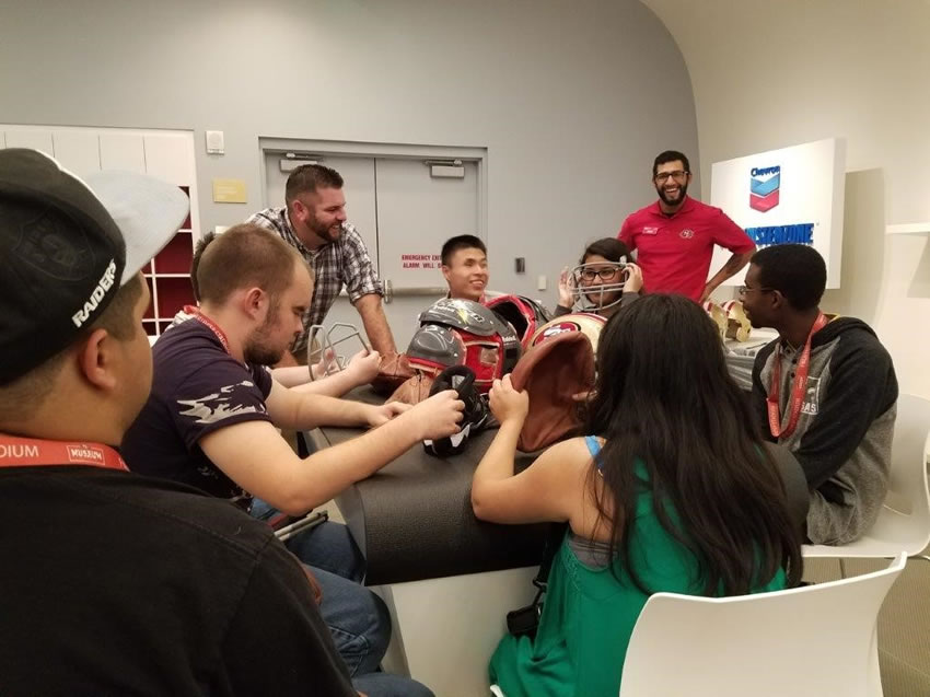 Six students participating in the Gearing Up for Football class at Levi Stadium with staff.