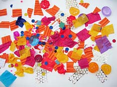 Multicolored collage of small paper squares, dots, and circles.