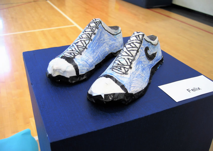 Paper mache blue athletic shoes with white cap toe.