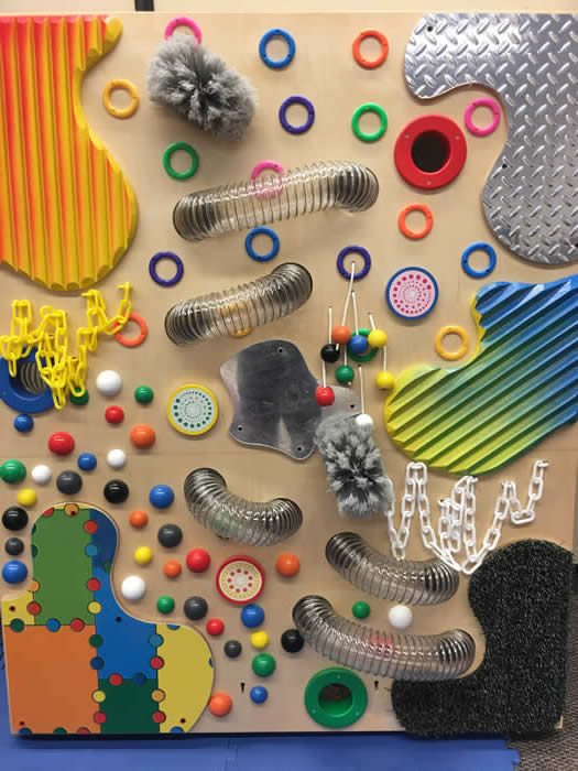 Tactile Wall with many objects attached to it, like beads, tubs, rings etc.