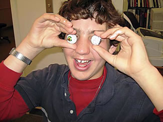 Eye Ball Classes Travis holds two chocolate candies that resemble eye balls, in front of his eyes.