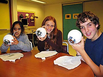 Eye Ball Classes Jot, Travis, Samantha holding models.