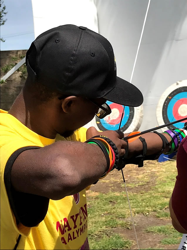 Student doing archery at Wayfinder Paralympic Games.