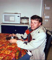 A student sitting at a table with a bowl in front of him.